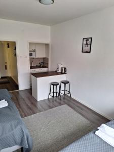 eine Küche mit einer Theke und 2 Hockern in einem Zimmer in der Unterkunft Varvinkatu apartment in Pori