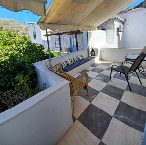 a patio with two chairs and an umbrella at Amaryllis Guest House in Hydra