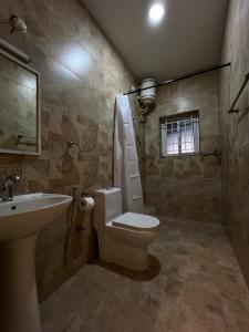 a bathroom with a toilet and a sink at Sunset Villa in Coonoor