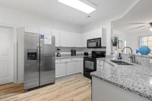 a kitchen with stainless steel appliances and white cabinets at Havens #1123 condo in North Myrtle Beach