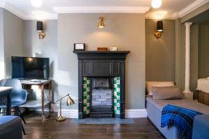 ein Wohnzimmer mit einem Kamin und einem Schreibtisch in der Unterkunft Sunshine in the Laines in Brighton & Hove