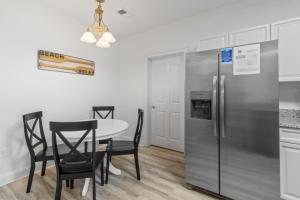 a kitchen with a table and a stainless steel refrigerator at Havens #1123 condo in North Myrtle Beach