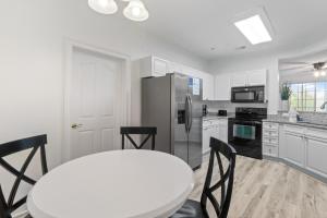 a kitchen with a white table and a refrigerator at Havens #1123 condo in North Myrtle Beach