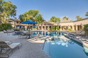 a swimming pool with chairs and a table and umbrella at 2bd/1ba North Scottsdale Condo in Scottsdale