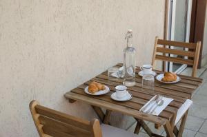a wooden table with plates of food and a bottle at La Capina in Letojanni