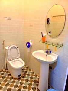 ein Badezimmer mit einem WC, einem Waschbecken und einem Spiegel in der Unterkunft NGUYỆT MINH HOTEL in Ấp Phú Lợi