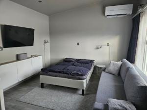 - une chambre avec un lit et un canapé dans l'établissement Gäststuga, nära Piteå havsbad., à Piteå