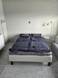 - une chambre blanche avec un lit et des oreillers noirs dans l'établissement Gäststuga, nära Piteå havsbad., à Piteå