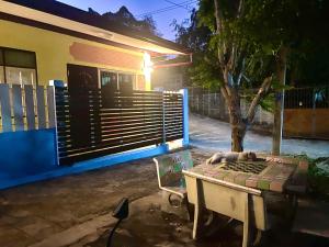 a bench in front of a house with a fence at สีชังสมายด์ in Ko Si Chang