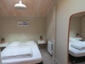 a small room with two beds and a mirror at La Belle Insulaire à Vert Bois in Dolus d'Oléron