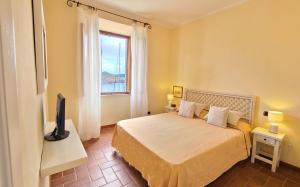 a bedroom with a bed with a television and a window at Casa Calata in Portoferraio