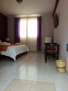 a bedroom with a bed and a table and a window at Hotel Isola in Aiquile