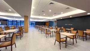 a dining room with tables and chairs at Hotel Diego de Almagro Pudahuel Aeropuerto in Santiago
