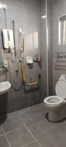 a bathroom with a shower with a toilet and a sink at perdana homestay in Ipoh