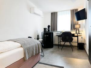 a bedroom with a bed and a desk with a computer at SI-View Einzelzimmer Zimmer 24 - Hotel in Siegen
