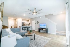a living room with a blue couch and a ceiling fan at Brand New Luxury -King Bed- 15 min to attractions in Saint Augustine