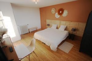 una camera con un letto bianco e una sedia bianca di B&B + sdb privées à Chatou, près de Paris a Chatou