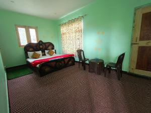 - une chambre avec un lit, des chaises et une table dans l'établissement Valley Guest House Pahalgam, à Kolur