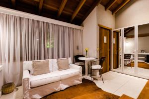 a living room with a white couch and a table at Solar Mirador Exclusive Resort e SPA in Praia do Rosa
