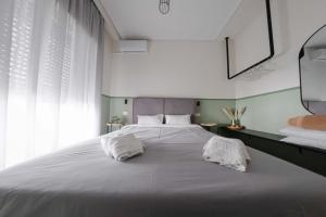 a bedroom with a large white bed with two pillows at Orsiida classic double room Volos in Volos