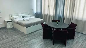 1 dormitorio con 1 cama, mesa y sillas en Loft Office 1, en Castel Maggiore