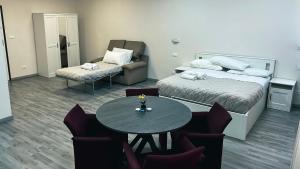 Habitación de hotel con cama, mesa y sillas en Loft Office 1, en Castel Maggiore
