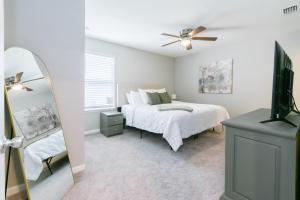 1 dormitorio con 1 cama con ventilador de techo y espejo en Brand New Luxury -King Bed- 15 min to attractions, en St. Augustine