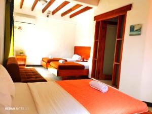 ein Hotelzimmer mit 2 Betten und einem Wohnzimmer in der Unterkunft Hostal GalaHouse in Puerto Ayora