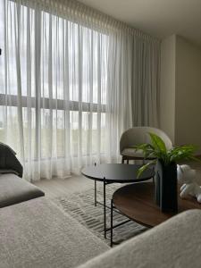 sala de estar con mesa y ventana grande en Arcadia Condo Suites, en Panamá