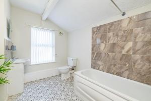 a bathroom with a tub and a toilet and a sink at Scott House - Contractor Friendly - Sleeps 7 in Liverpool +14 photos