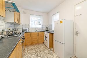 a kitchen with a white refrigerator and a dishwasher at Scott House - Contractor Friendly - Sleeps 7 in Liverpool