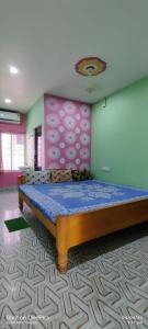 a bedroom with a large bed in a room at Anirudha Guest House in Digha