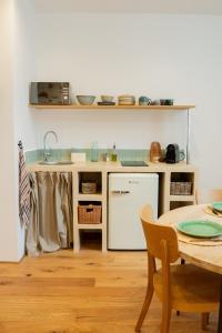 a kitchen with a table and a sink and a dishwasher at La Maison des Lamanon in Salon-de-Provence