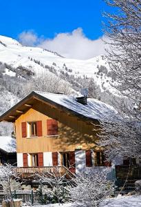 una casa cubierta de nieve en una montaña en appartement en duplex dans un chalet typique, en Valloire