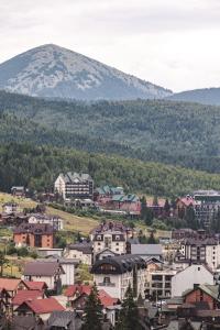 een klein stadje met een berg op de achtergrond bij Olimp Hotel in Boekovel