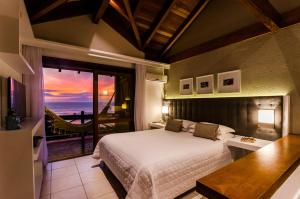 a bedroom with a bed and a view of the ocean at Solar Mirador Exclusive Resort e SPA in Praia do Rosa +37 photos