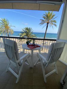 una mesa y 2 sillas en un balcón con vistas al océano en El Velero una terraza al mar, en Calafell