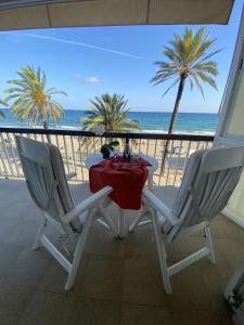 una mesa y 2 sillas en un balcón con vistas al océano en El Velero una terraza al mar, en Calafell