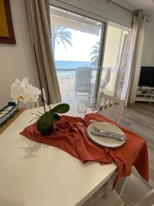 una mesa con un plato y vasos y vistas al océano en El Velero una terraza al mar, en Calafell