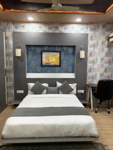 Hotel Roayal International By Le Cashew Rooms في نيودلهي: غرفة نوم بسرير كبير بجدار ازرق