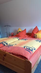 a twin bed with colorful pillows on it at Moni in Ummanz