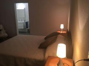 a bedroom with a bed with two lamps on tables at Modern apartment easy commute, Geneva & Nyon 75m2 in Founex