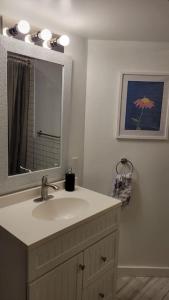 a bathroom with a sink and a mirror at Beautiful newly designed Luxurious Apartment in Windsor