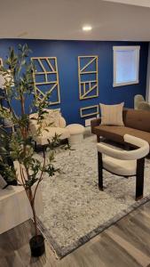 un soggiorno con parete blu, divano e albero di Beautiful newly designed Luxurious Apartment a Windsor