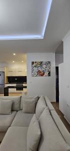 ein Wohnzimmer mit einem Sofa und einer Küche in der Unterkunft TAM 2BDR Centre Apartment With Veranda in Tirana