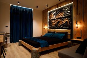 1 dormitorio con 1 cama con una pintura en la pared en The Barrels Ms en Gjirokastër
