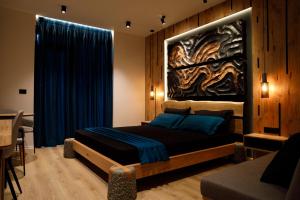 a bedroom with a bed with a painting on the wall at The Barrels Ms in Gjirokastër