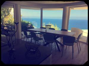 een tafel en stoelen in een kamer met uitzicht op de oceaan bij Villa with DREAM VIEW and SWIMMING POOL!! in Les Issambres