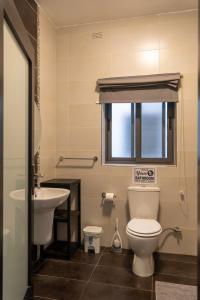 uma casa de banho com um WC, um lavatório e uma janela em Cozy Bedroom, shared bathroom -Gzira em Il-Gżira