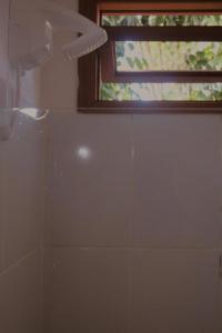 a bathroom with a shower and a window at Casa Azul Caraíva - Casas Do San in Caraíva